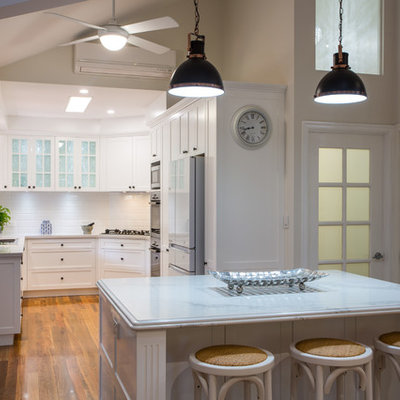Inspiration for a large timeless u-shaped medium tone wood floor and brown floor open concept kitchen remodel in Brisbane with a double-bowl sink, shaker cabinets, white cabinets, quartz countertops, white backsplash, subway tile backsplash, black appliances and an island