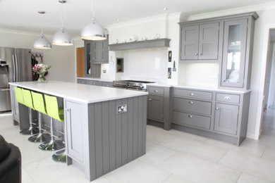 Large traditional open plan kitchen in West Midlands with a built-in sink, grey cabinets, quartz worktops, white splashback, stainless steel appliances, an island and white worktops.