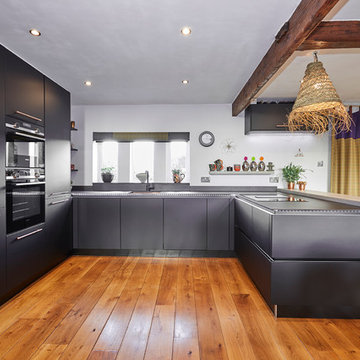 Handle-less Black kitchen with Copper accents & bespoke Concrete breakfast bar