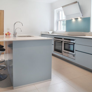 Handle-less matt blue kitchen with modern appliances