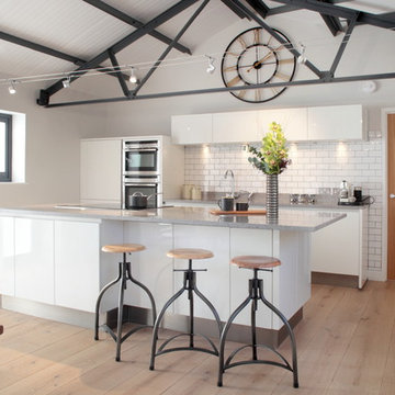 Handle-less white barn conversion kitchen with large island