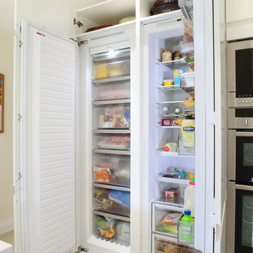 Handle-less white kitchen with integrated tall fridge/freezer