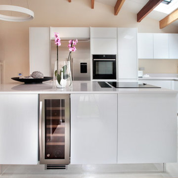 Handle-less white kitchen with wine cooler in island