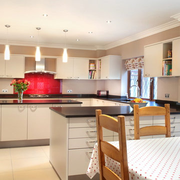 Handled contemporary kitchen with red splash back