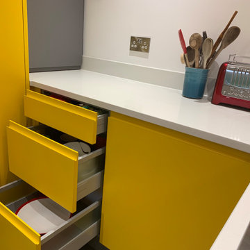 Handless family kitchen in custom yellow and mid grey