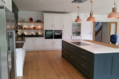 Modern kitchen in Berkshire with a belfast sink, shaker cabinets, quartz worktops and an island.