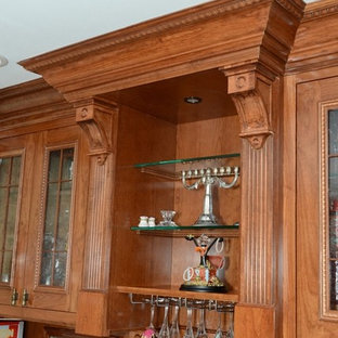 Example of a classic kitchen design in New York with medium tone wood cabinets and an island