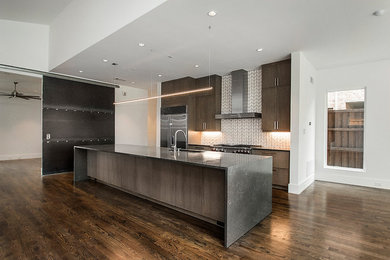 Inspiration for a modern galley dark wood floor and brown floor open concept kitchen remodel in Dallas with flat-panel cabinets, medium tone wood cabinets, quartz countertops, white backsplash, ceramic backsplash, stainless steel appliances and an island