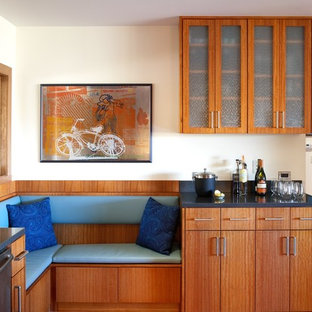 Inspiration pour une cuisine minimaliste avec un placard à porte vitrée, des portes de placard en bois brun et un électroménager en acier inoxydable.
