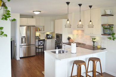 Mid-sized transitional u-shaped medium tone wood floor and brown floor eat-in kitchen photo in Other with shaker cabinets, white cabinets, white backsplash, a peninsula, quartzite countertops, an undermount sink, stone tile backsplash and stainless steel appliances