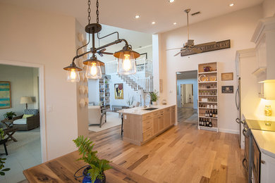 Large transitional single-wall light wood floor eat-in kitchen photo in Miami with an undermount sink, shaker cabinets, white cabinets, solid surface countertops, multicolored backsplash, matchstick tile backsplash, stainless steel appliances and an island