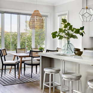 Inspiration pour une grand cuisine ouverte traditionnelle en L avec un sol en bois clair, un sol marron, un plafond voûté, un évier de ferme, un placard à porte shaker, des portes de placard blanches, un plan de travail en marbre, une crédence blanche, une crédence en carrelage métro, un électroménager en acier inoxydable, un îlot central et un plan de travail blanc.