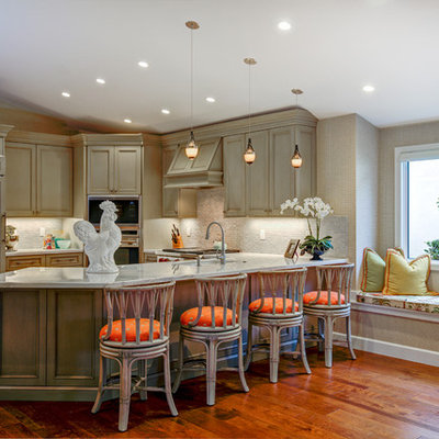 Inspiration for a tropical l-shaped medium tone wood floor and orange floor enclosed kitchen remodel in Miami with an undermount sink, beaded inset cabinets, distressed cabinets, gray backsplash, mosaic tile backsplash, paneled appliances and a peninsula