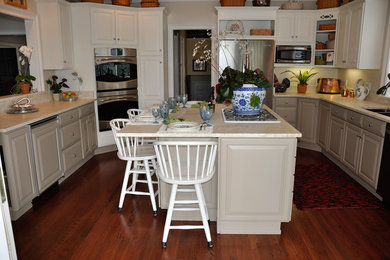 Example of a trendy kitchen design with a double-bowl sink, shaker cabinets, quartzite countertops and an island