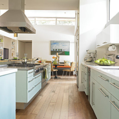 Large 1960s galley dark wood floor open concept kitchen photo in Miami with an undermount sink, flat-panel cabinets, blue cabinets, solid surface countertops, stainless steel appliances and two islands