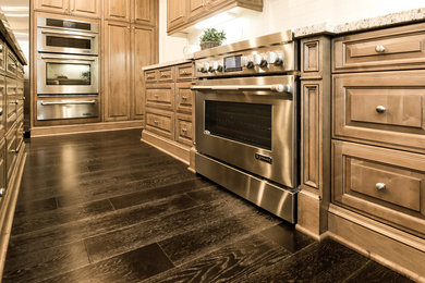 Example of a large classic u-shaped dark wood floor kitchen design in Los Angeles with medium tone wood cabinets, stainless steel appliances and an island
