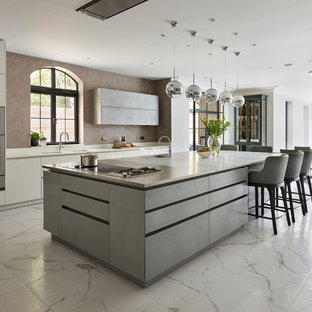 Design ideas for an expansive contemporary open plan kitchen in London with flat-panel cabinets, white cabinets, granite worktops, an island, white worktops and white floors.