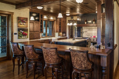 Inspiration for a large timeless u-shaped medium tone wood floor and brown floor kitchen remodel in Charlotte with an undermount sink, raised-panel cabinets, dark wood cabinets, wood countertops, beige backsplash, subway tile backsplash, paneled appliances and an island