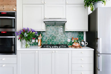 Идея дизайна: прямая кухня-гостиная среднего размера в стиле неоклассика (современная классика) с зеленым фартуком, фартуком из керамической плитки и полом из керамогранита