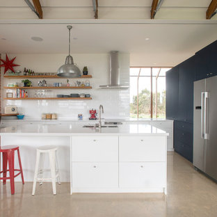 Inspiration for a contemporary l-shaped eat-in kitchen in Adelaide with an undermount sink, flat-panel cabinets, white cabinets, white splashback, stainless steel appliances, concrete floors, with island, beige floor and white benchtop.