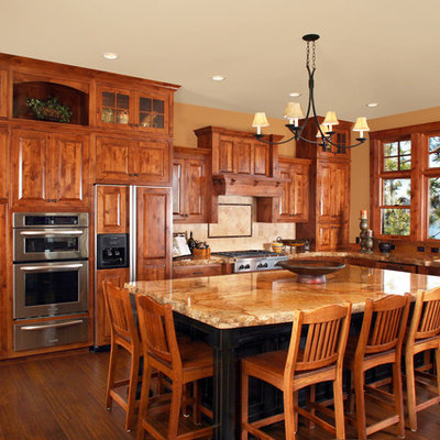 Inspiration for a rustic l-shaped kitchen remodel in Other with raised-panel cabinets, dark wood cabinets, granite countertops and paneled appliances