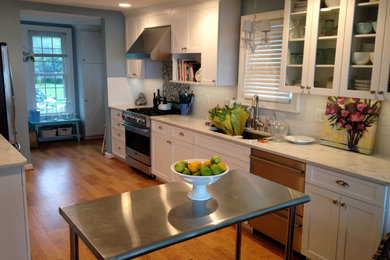 Inspiration for a mid-sized contemporary galley light wood floor and beige floor eat-in kitchen remodel in Detroit with an undermount sink, recessed-panel cabinets, white cabinets, marble countertops, white backsplash, ceramic backsplash, stainless steel appliances and no island