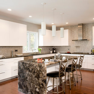 Diseño de cocina en U, contemporánea, grande, con salpicadero con mosaicos de azulejos, electrodomésticos de acero inoxidable, armarios con paneles lisos, puertas de armario blancas, suelo de madera en tonos medios, una isla, fregadero bajoencimera, encimera de cuarzo compacto y salpicadero verde