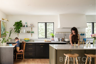 Light wood floor kitchen photo in Denver with an undermount sink, flat-panel cabinets, dark wood cabinets, an island and white countertops