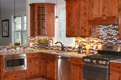 Example of a mid-sized arts and crafts l-shaped medium tone wood floor eat-in kitchen design in Boston with an undermount sink, shaker cabinets, dark wood cabinets, granite countertops, multicolored backsplash, porcelain backsplash, stainless steel appliances and a peninsula
