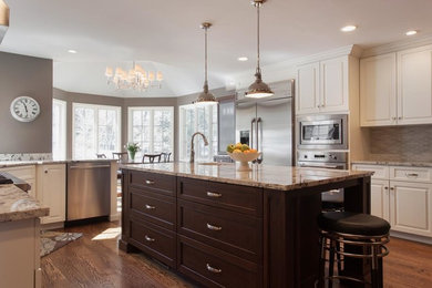 Inspiration for a large transitional u-shaped dark wood floor and brown floor eat-in kitchen remodel in Philadelphia with an undermount sink, raised-panel cabinets, white cabinets, granite countertops, beige backsplash, porcelain backsplash, stainless steel appliances and multicolored countertops