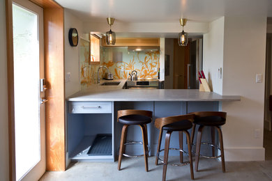 Example of a small minimalist u-shaped concrete floor and gray floor eat-in kitchen design in Portland with an undermount sink, shaker cabinets, gray cabinets, concrete countertops, multicolored backsplash, glass sheet backsplash, stainless steel appliances, no island and gray countertops