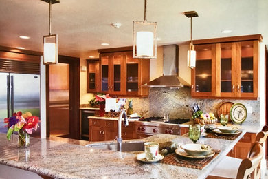 ハワイにある高級な広いトランジショナルスタイルのおしゃれなキッチン (アンダーカウンターシンク、シェーカースタイル扉のキャビネット、中間色木目調キャビネット、御影石カウンター、マルチカラーのキッチンパネル、石スラブのキッチンパネル、シルバーの調理設備、スレートの床、グレーの床、マルチカラーのキッチンカウンター) の写真