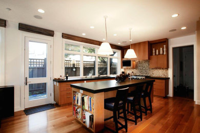 Large transitional u-shaped medium tone wood floor and brown floor eat-in kitchen photo in San Francisco with an undermount sink, flat-panel cabinets, medium tone wood cabinets, granite countertops, beige backsplash, matchstick tile backsplash, stainless steel appliances and an island