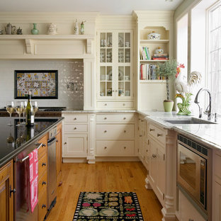 Elegant l-shaped light wood floor eat-in kitchen photo in Boston with an undermount sink, flat-panel cabinets, white cabinets, stainless steel appliances and white backsplash