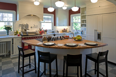 Transitional porcelain tile and gray floor eat-in kitchen photo in Seattle with recessed-panel cabinets, white cabinets, wood countertops, white backsplash, ceramic backsplash, colored appliances, an island and an undermount sink