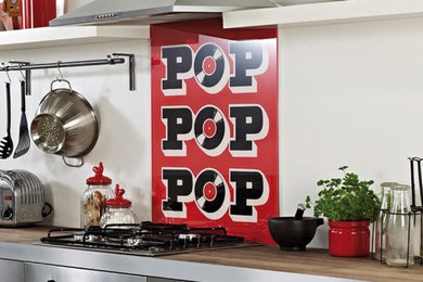 ハートフォードシャーにある低価格のコンテンポラリースタイルのおしゃれなキッチン (赤いキッチンパネル、ガラス板のキッチンパネル) の写真