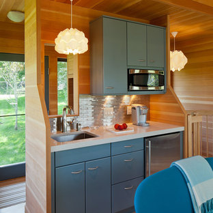 Imagen de cocina rústica, pequeña, con fregadero bajoencimera, armarios con paneles lisos, puertas de armario azules, encimera de cuarzo compacto, salpicadero metalizado, salpicadero de metal, electrodomésticos de acero inoxidable y suelo de madera clara