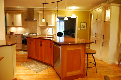 Inspiration for a transitional light wood floor kitchen remodel in Ottawa with an undermount sink, flat-panel cabinets, beige cabinets, quartz countertops, beige backsplash, porcelain backsplash, stainless steel appliances and an island