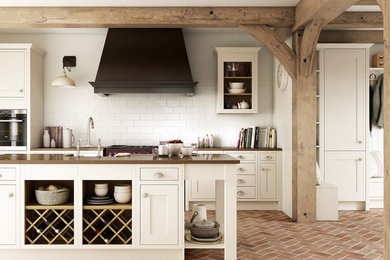 他の地域にある広いトラディショナルスタイルのおしゃれなキッチン (一体型シンク、シェーカースタイル扉のキャビネット、白いキャビネット、珪岩カウンター、白いキッチンパネル、サブウェイタイルのキッチンパネル、レンガの床) の写真
