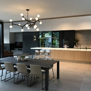 Design ideas for an expansive contemporary galley eat-in kitchen in Melbourne with an undermount sink, flat-panel cabinets, black cabinets, grey splashback, panelled appliances, porcelain floors, with island, grey floor and white benchtop.