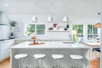 Eat-in kitchen - large modern l-shaped light wood floor and brown floor eat-in kitchen idea in Vancouver with an undermount sink, flat-panel cabinets, white cabinets, quartz countertops, white backsplash, porcelain backsplash, stainless steel appliances, an island and white countertops