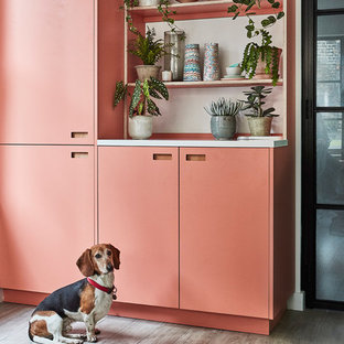 This is an example of a mid-sized scandinavian l-shaped eat-in kitchen in London with an undermount sink, flat-panel cabinets, turquoise cabinets, solid surface benchtops, white splashback, subway tile splashback, panelled appliances, porcelain floors, no island, grey floor and white benchtop.