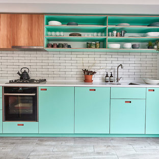 Esempio di una cucina nordica di medie dimensioni con lavello sottopiano, ante turchesi, top in superficie solida, paraspruzzi bianco, paraspruzzi con piastrelle diamantate, pavimento in gres porcellanato, nessuna isola, pavimento grigio, top bianco e nessun'anta