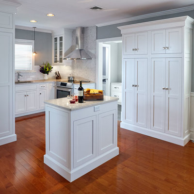 Inspiration for a small craftsman u-shaped medium tone wood floor eat-in kitchen remodel in Other with an undermount sink, shaker cabinets, white cabinets, quartz countertops, white backsplash, porcelain backsplash, stainless steel appliances and an island
