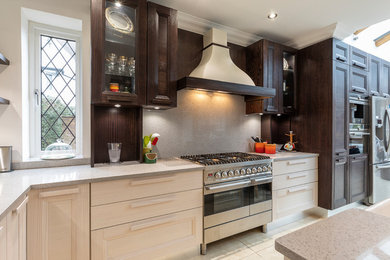 Klassisk inredning av ett grå grått kök med öppen planlösning, med en rustik diskho, skåp i shakerstil, bruna skåp, bänkskiva i kvartsit, grått stänkskydd, stänkskydd i sten, rostfria vitvaror och en köksö