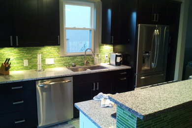 Trendy enclosed kitchen photo in Denver with an undermount sink, shaker cabinets, black cabinets, quartzite countertops, green backsplash and stainless steel appliances