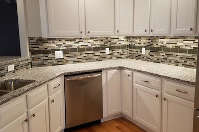 Enclosed kitchen - mid-sized transitional u-shaped light wood floor and brown floor enclosed kitchen idea in Other with a double-bowl sink, shaker cabinets, white cabinets, granite countertops, multicolored backsplash, glass tile backsplash, no island and gray countertops