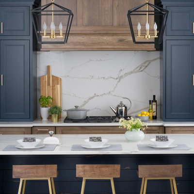 Open concept kitchen - mid-sized country medium tone wood floor and brown floor open concept kitchen idea in Boston with a farmhouse sink, blue cabinets, quartz countertops, white backsplash, stone slab backsplash, stainless steel appliances, an island, brown countertops and recessed-panel cabinets