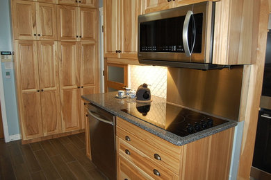 Example of a mid-sized classic galley ceramic tile enclosed kitchen design in Other with an undermount sink, raised-panel cabinets, light wood cabinets, quartz countertops, white backsplash, ceramic backsplash and stainless steel appliances