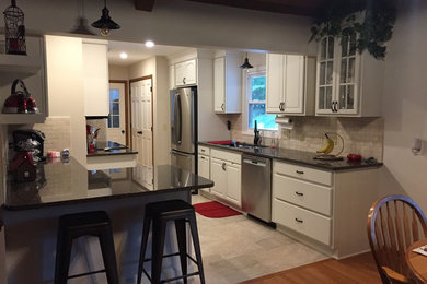 Example of a galley ceramic tile and multicolored floor eat-in kitchen design in Charlotte with white cabinets, granite countertops, multicolored backsplash, marble backsplash, stainless steel appliances and a peninsula